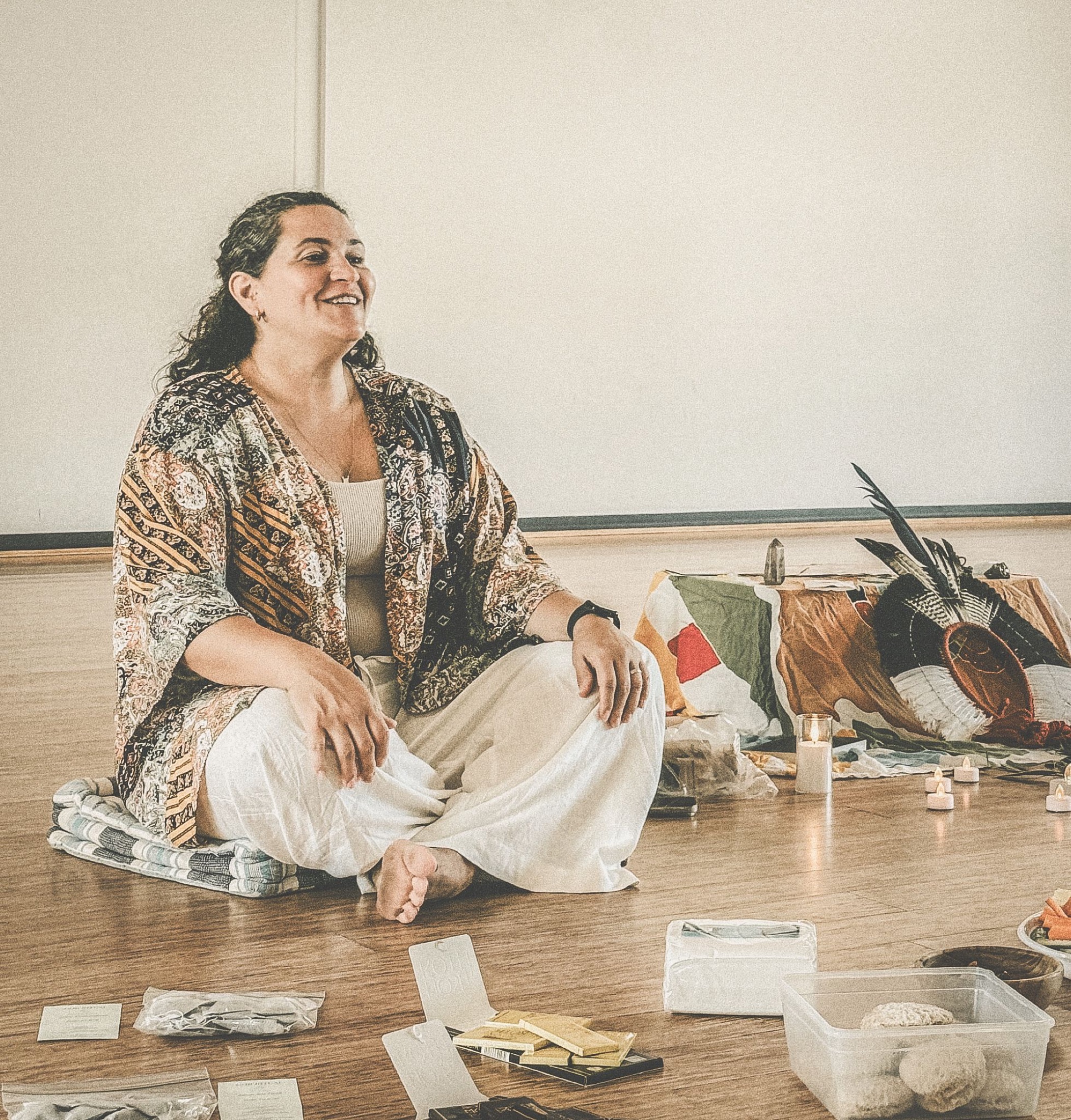 Thaysa seated beside ceremonial objects during a group circle
